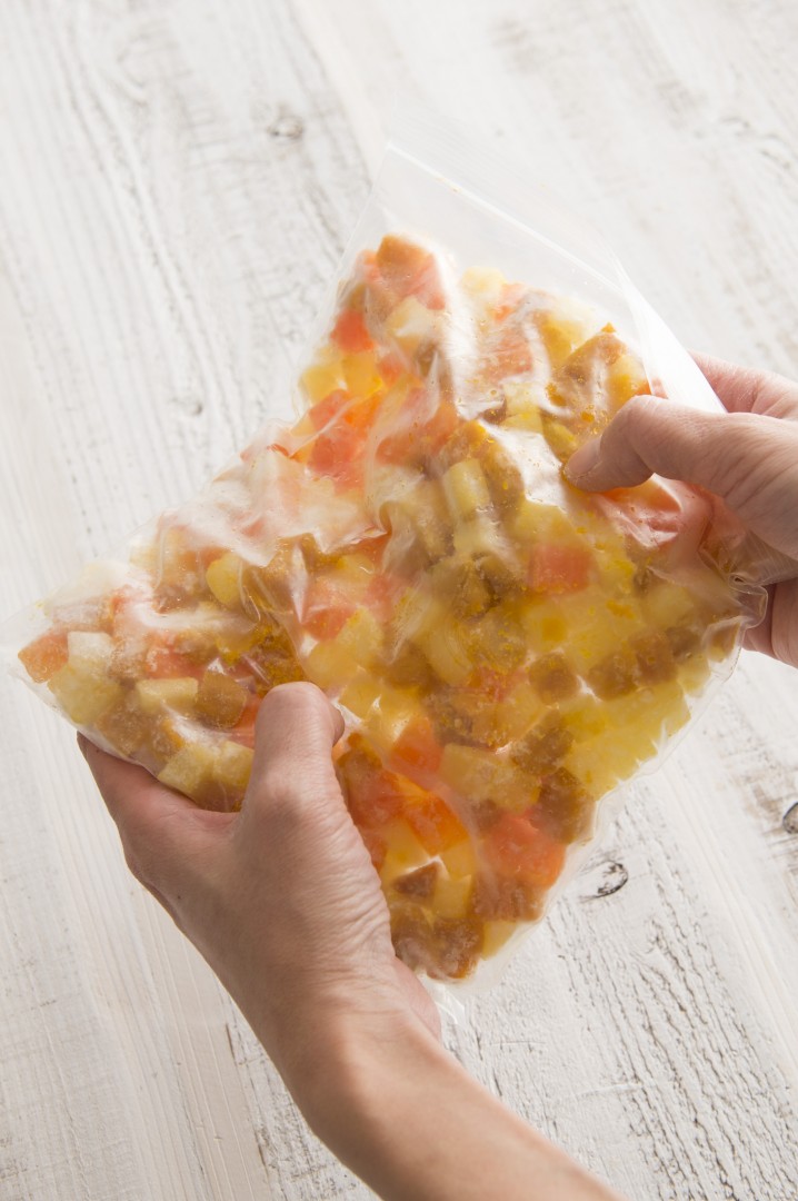 野菜が半分ほど凍ったら、手でもんでほぐして容器に移して冷凍。