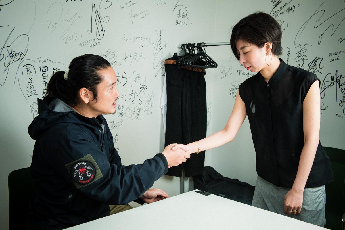 軽いウェーブを送られる編集のTさん