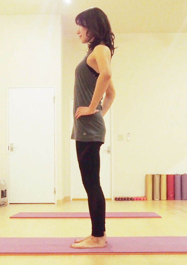 床に立ち、足を腰幅に開いたら腰に手をあてる