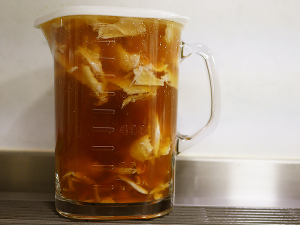 ほぐした手羽先をつゆに戻す