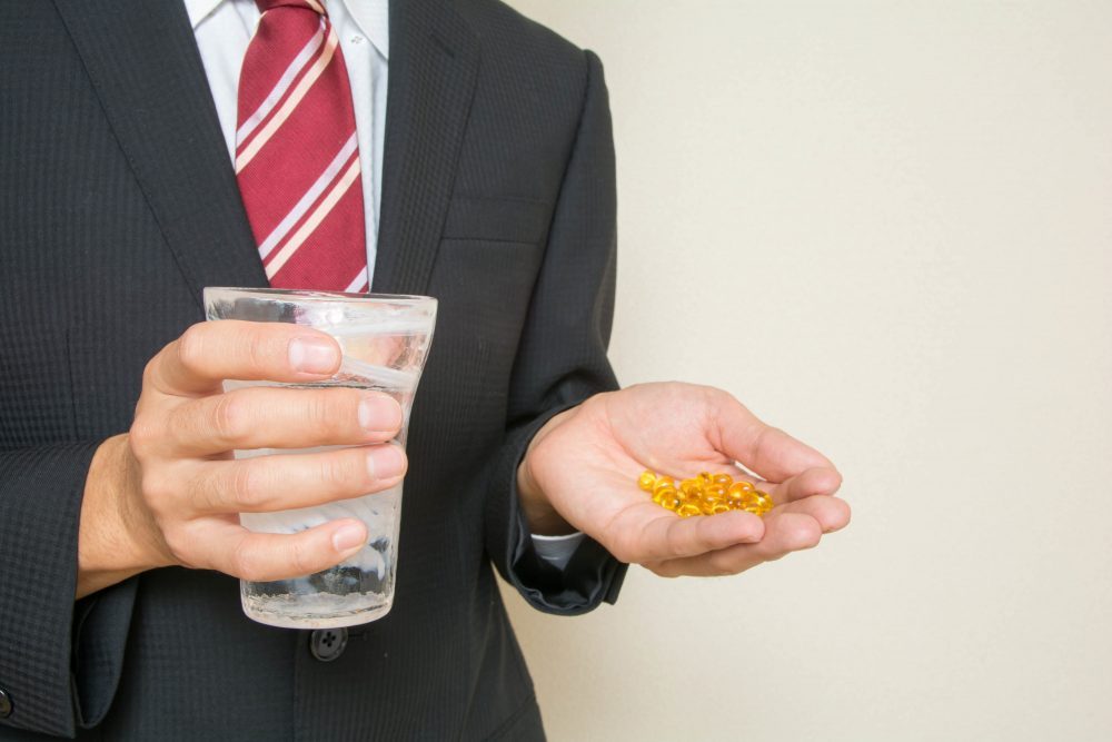 サプリメントで食事を済ます男性