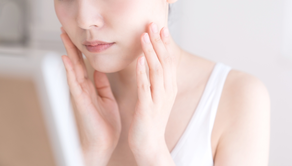 鏡を見る女性、顔のむくみ