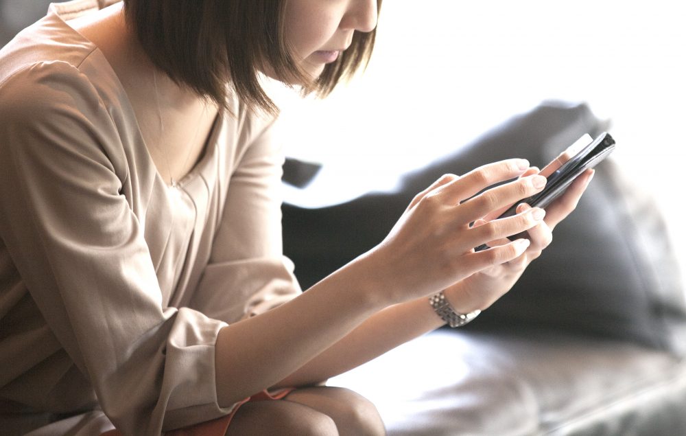 SNSをスマホでチェックする女性