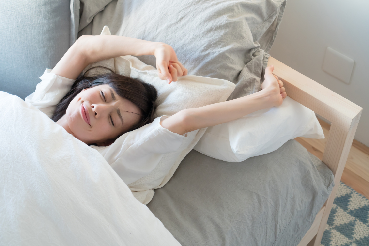 朝　ベッド　伸びる女性