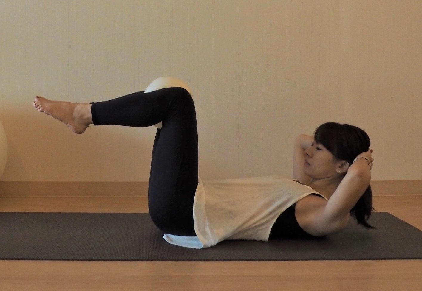 (2) ひざを曲げた状態で足を床から浮かせ、両手は後頭部に。