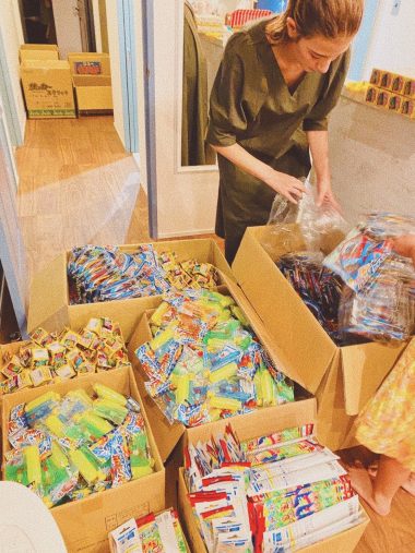 「ニコニコ大作戦」と題し、被災地の小学校に届ける駄菓子を詰めているスザンヌさん