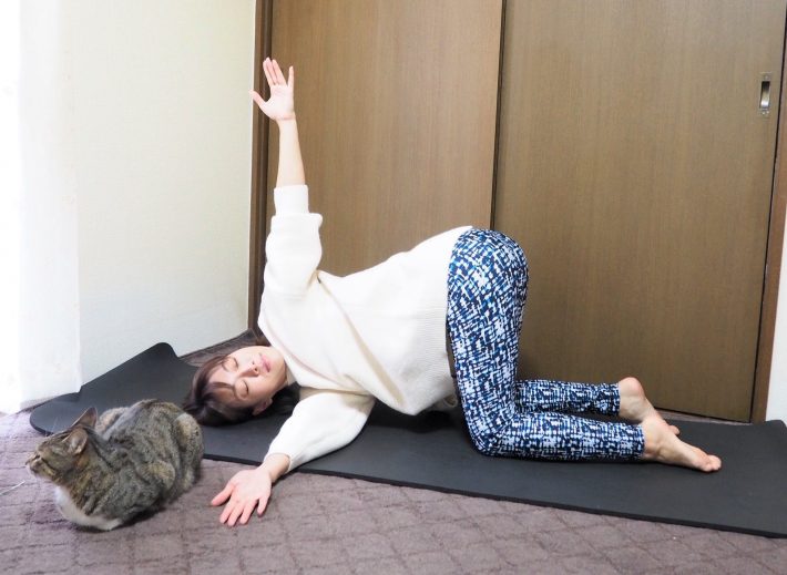 (2)右手のひらを上に向けたら左脇の下をくぐらせ、右の肩・こめかみを床につける。