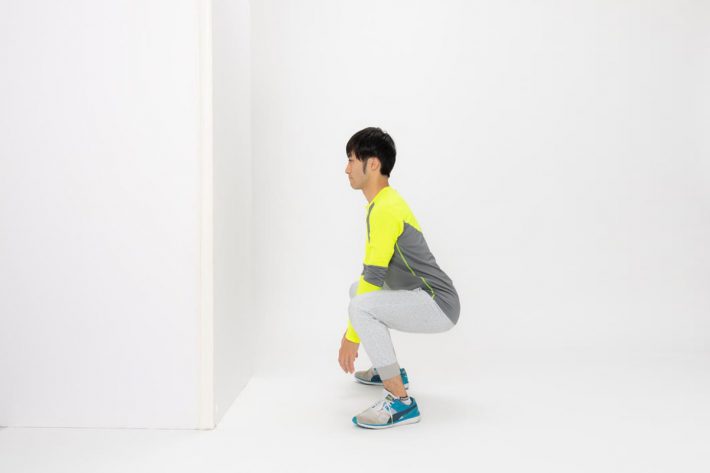 ②足を肩幅よりも少し広くし、スクワットをするようにお尻を後ろに引いて腰を落とします。