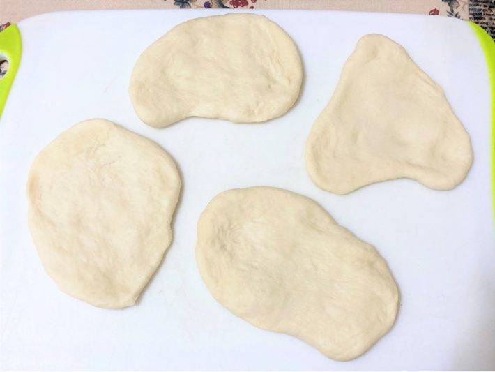 4等分したナンをまな板の上で伸ばします
