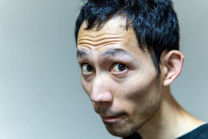 目を見開いてこちらを見つめる男性