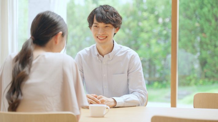 室内で会話をする若いカップル