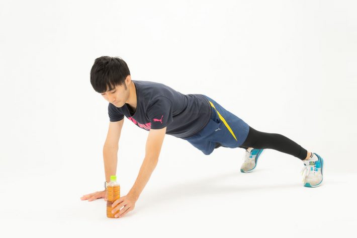 右手で体を支えながら左でペットボトルを持つ