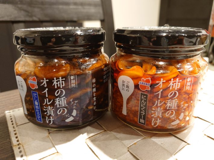 左「柿の種のオイル漬けだし醤油仕立て」、右「柿の種のオイル漬けにんにくラー油」