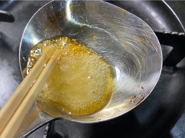 2.割り箸でかき混ぜながら砂糖を溶かす。