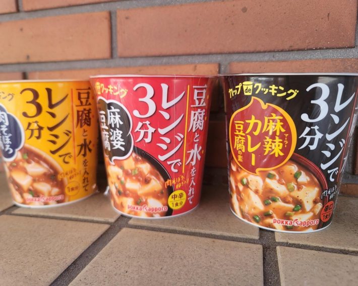 カップタイプのレンチンする麻婆豆腐（中央）。カップ de クッキングシリーズの3種（肉そぼろ豆腐、麻婆豆腐、麻辣カレー豆腐）（希望小売価格：それぞれ税別180円）