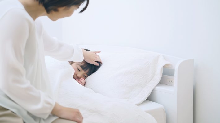 女の子を寝かしつける女性　子育て・保育イメ