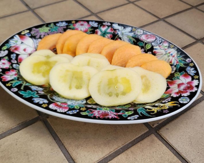 旬（執筆時）のりんごと柿を並べてみました。蜜がたっぷり入っていたので芯はそのままに