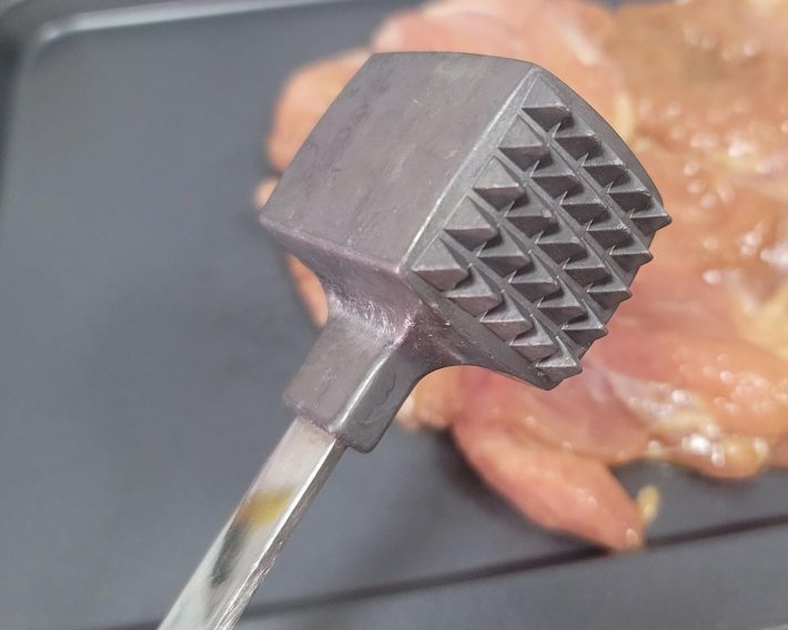 肉たたきで鶏肉を叩いて薄く平らに伸ばしていこう