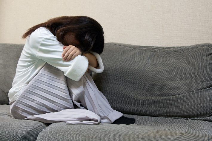 顔を伏せて泣く女性