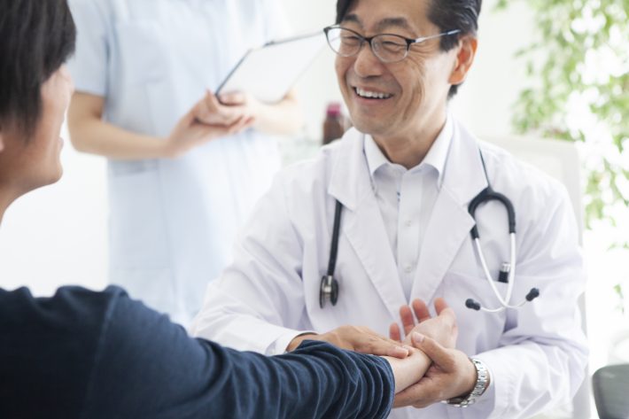 笑顔で患者の不安を和らげる医師
