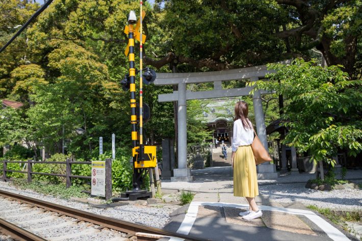 神社の前に立つ女性