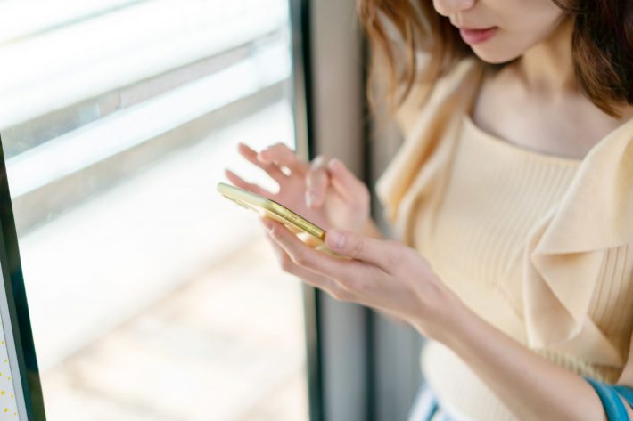 電車内でスマホを操作する女性
