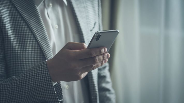 スマホをさわる男性の手