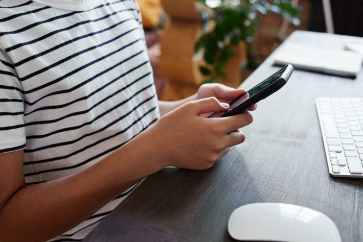 スマホをいじる子供の手