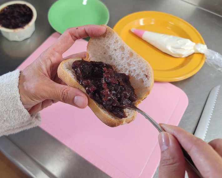 クルミパンにあんこを塗り広げています