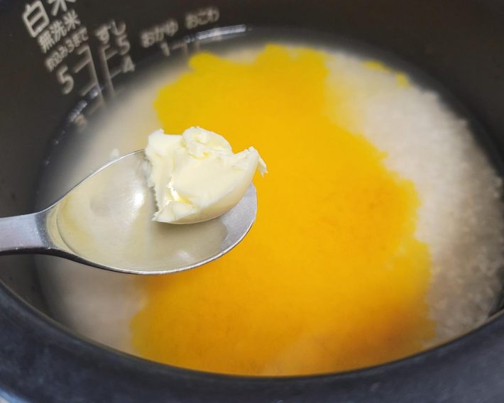 ターメリックとバターを加えて、炊飯ボタンを押しましょう。ターメリックを写真のように混ぜないで炊くと、仕上がりの色ムラがやや出るためオススメは軽く混ぜることです