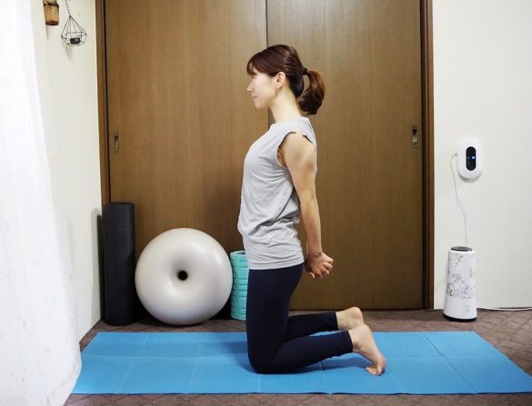 （1）床にひざ立ちになり、お尻の位置で両手の指を組む