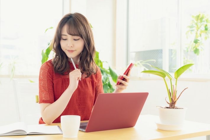 ノートとパソコンに向かう女性