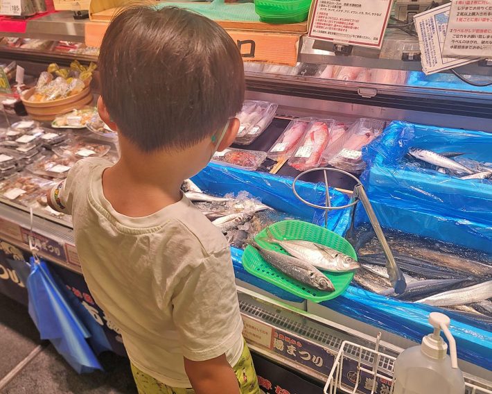 スーパーマーケットの魚売り場。自分で選んだ魚を、お店スタッフさんにさばいてもらおうとしています