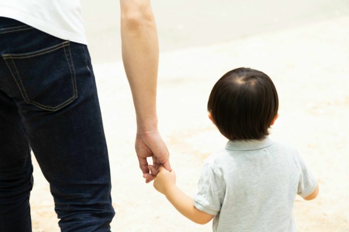 父親と手を繋いで歩く男の子