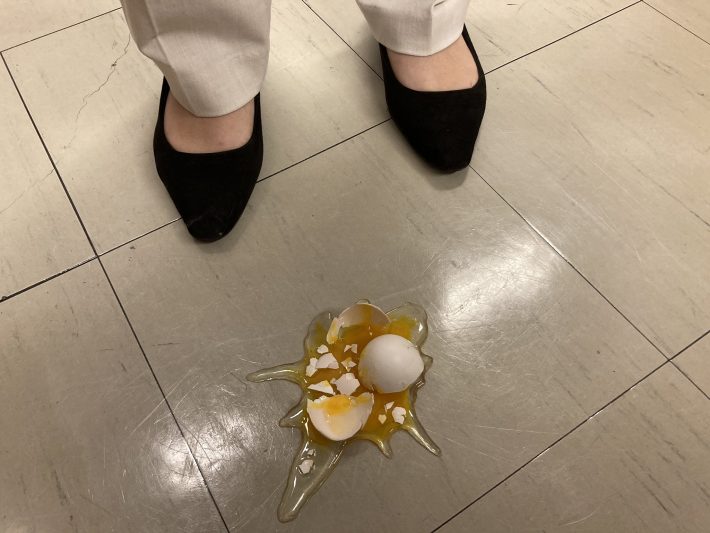 床に置いた割れた卵の食品サンプル