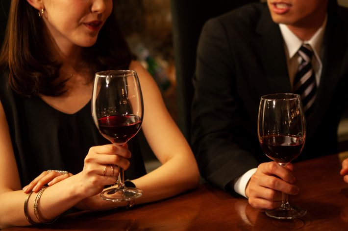 ワイングラスと女性の手元