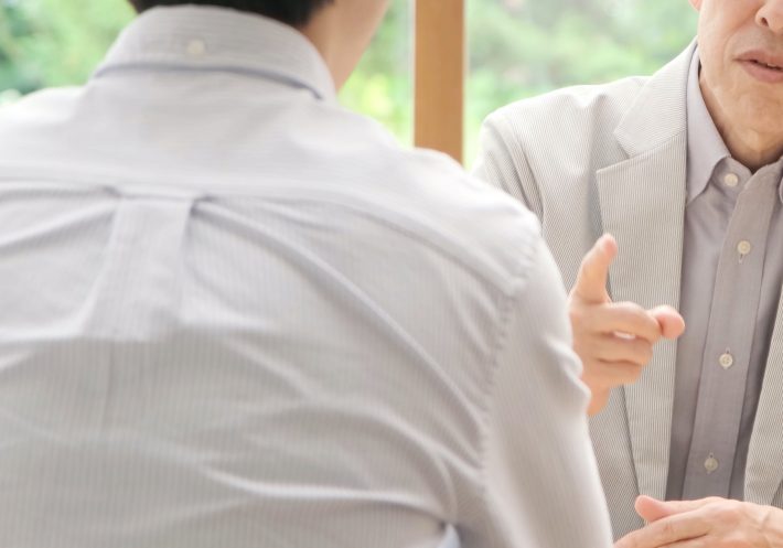 家族に説教をする高齢の男性