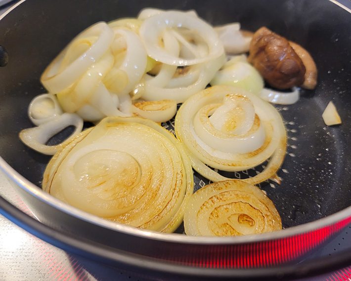 玉ねぎをタテに輪切りにして、牛脂で焼いています