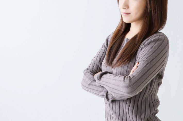 腕を組んで考え込む女性