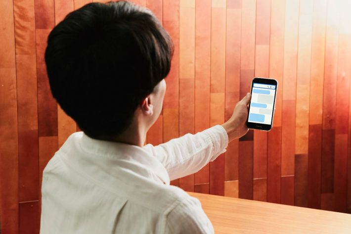 スマホ画面に見入る男性