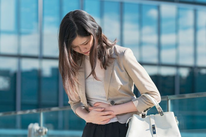 腹部が痛いビジネスウーマン