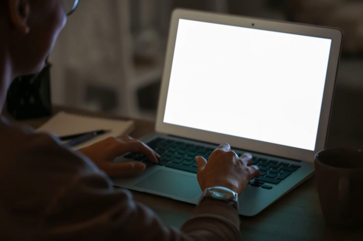 暗闇でPCを操作する人