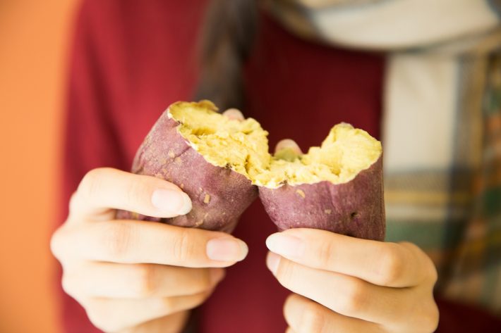 焼き芋を割る女性