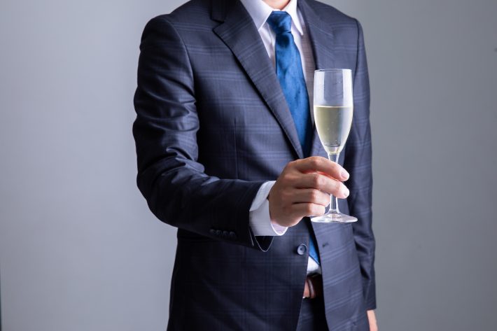 シャンパングラスを持ったスーツの男性