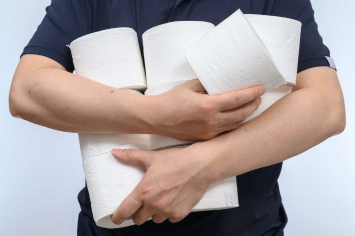 トイレットペーパーを抱える男