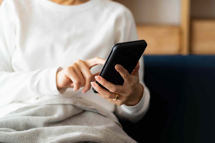 スマートフォンを見るミドル女性の手元