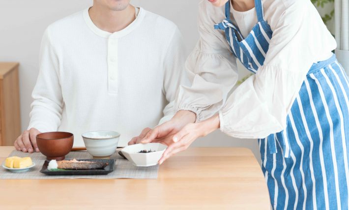 夫に料理を作る妻（料理・朝食・自炊・和食・健康）