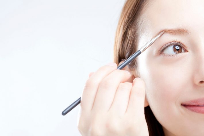 眉毛をかく女性