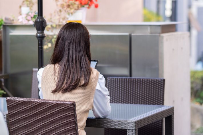 カフェでスマホを触る女性