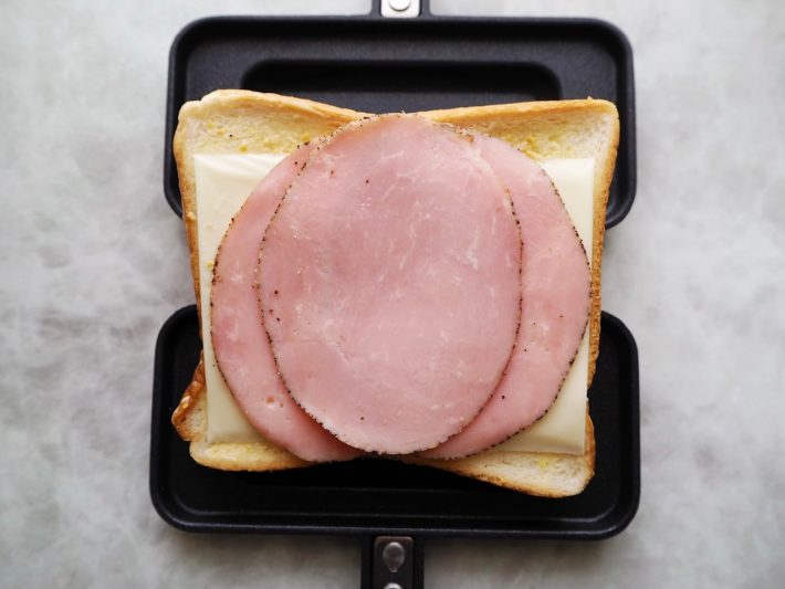 食パンの上に、溶けるチーズ2枚とハムを3枚置く